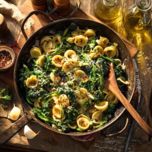 Orecchiette pasta with broccoli rabe in a frying pan.