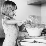 A young girl learning how to cook in Mom's kitchen