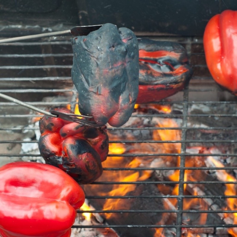 Roasting peppers over a hot grill.