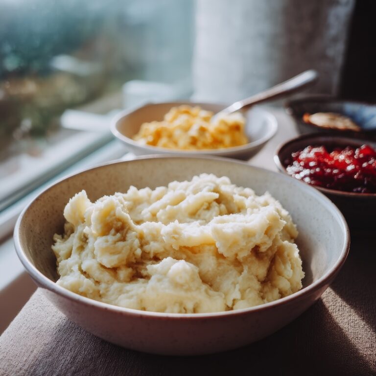 bowl of creamy mashed potatoes beside applesauce and scrambled eggs