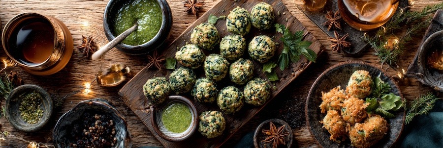 spinach balls served with dipping sauces and holiday appetizers on a wooden table