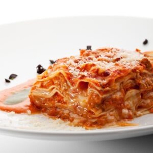 A cut of lasagna sitting on white plate