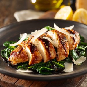 Pan-roasted chicken breasts with a soy-honey-mirin glaze, lightly floured and seared to golden brown, sliced and served over a bed of glossy sauteed spinach.