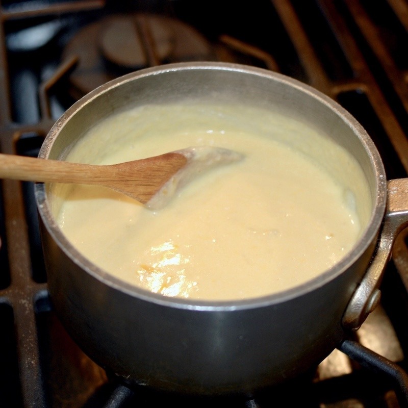 Mornay sauce being stirred in a saucepan