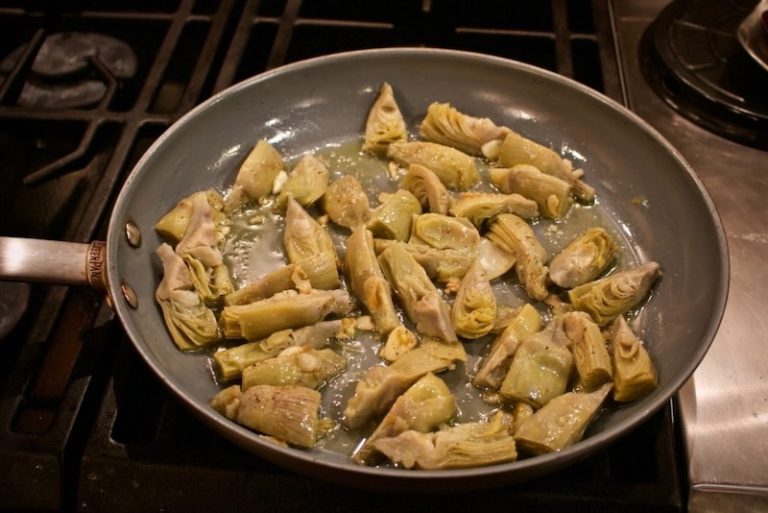 sauteeing artichoke hearts in a fry pan