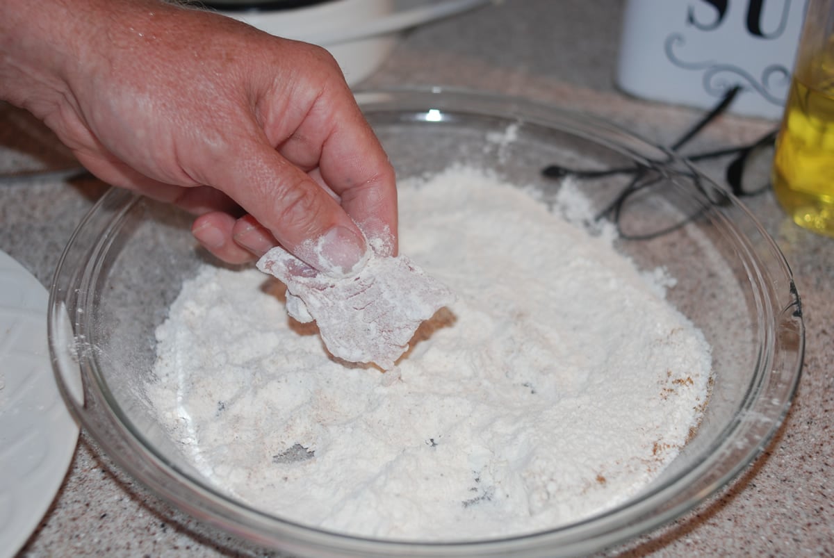 Dipping fish into flour