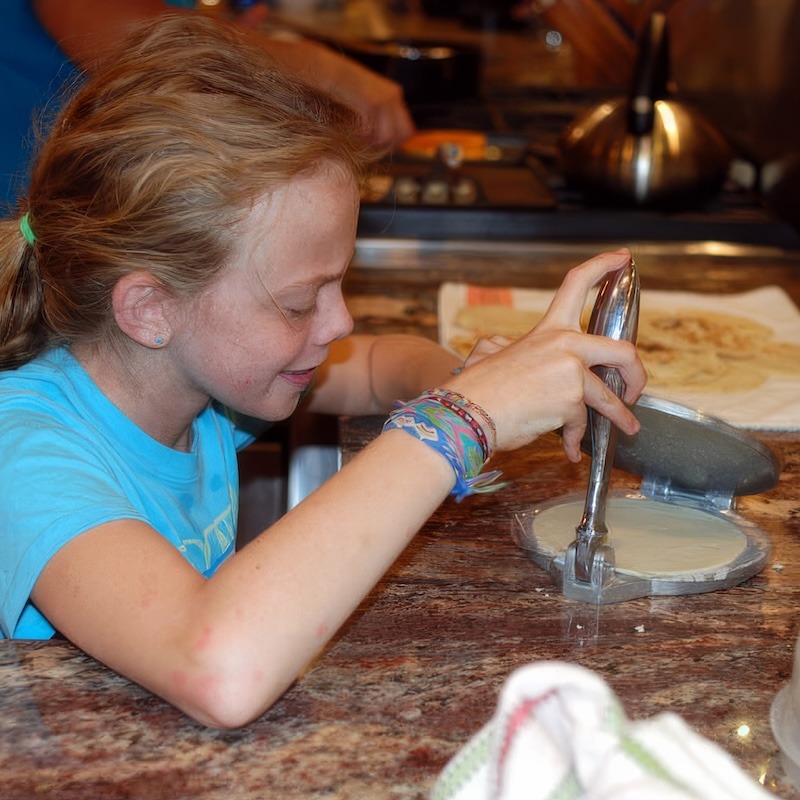 My daughter preparing tortillas in a press