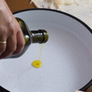 Adding oil to a pan.