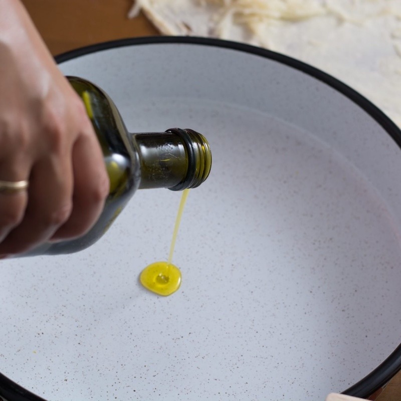 Adding oil to a pan.