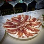 A plate filled with slices of jamon iberico ham.