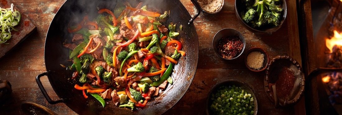 high-heat stir fry in action, a large wok