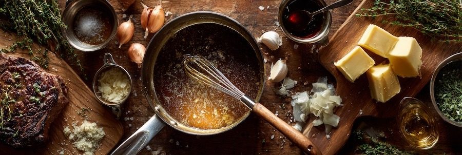 classic pan sauce making in progress on a rustic kitchen workbench